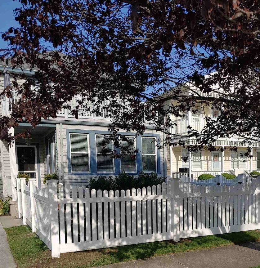 White picket fence and gate in front of a home